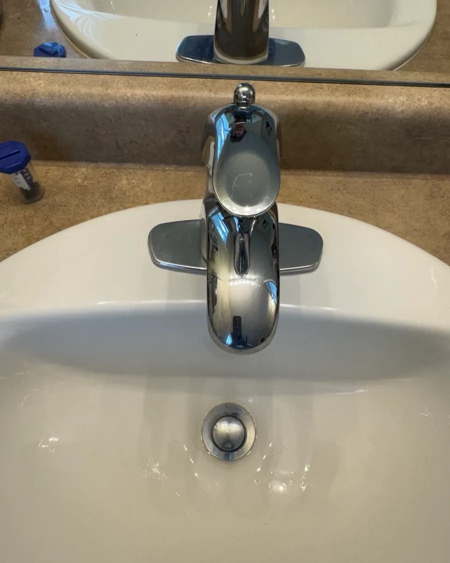 The same chrome faucet and white sink, clean