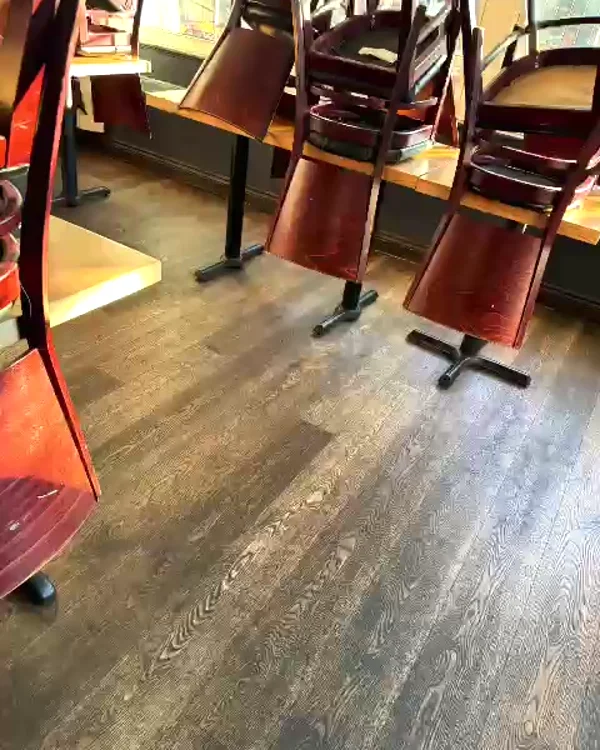 The same dining room floor cleaned, chairs up on the tables