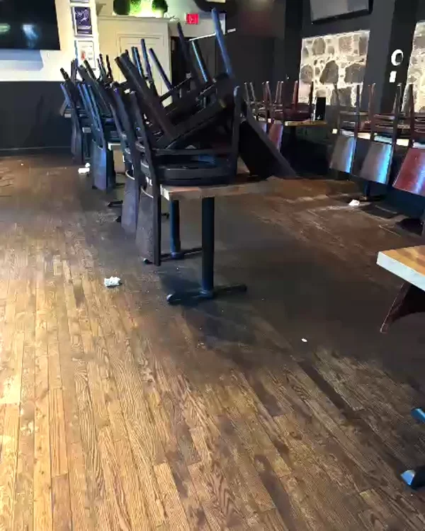 Restaurant dining room with litter on the wood floor