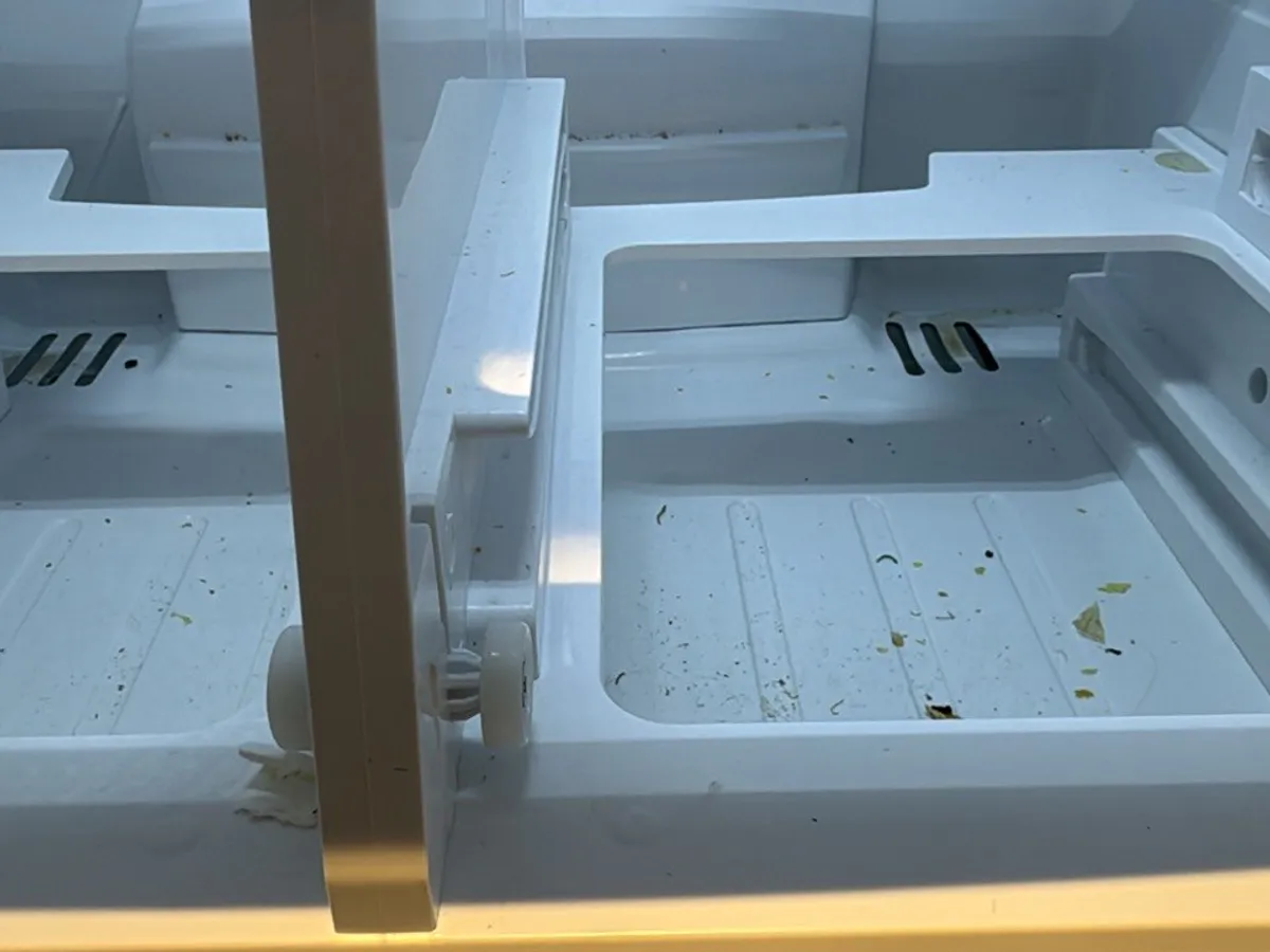 Two fridge drawer bays with crumbs and dried spills on the bottom