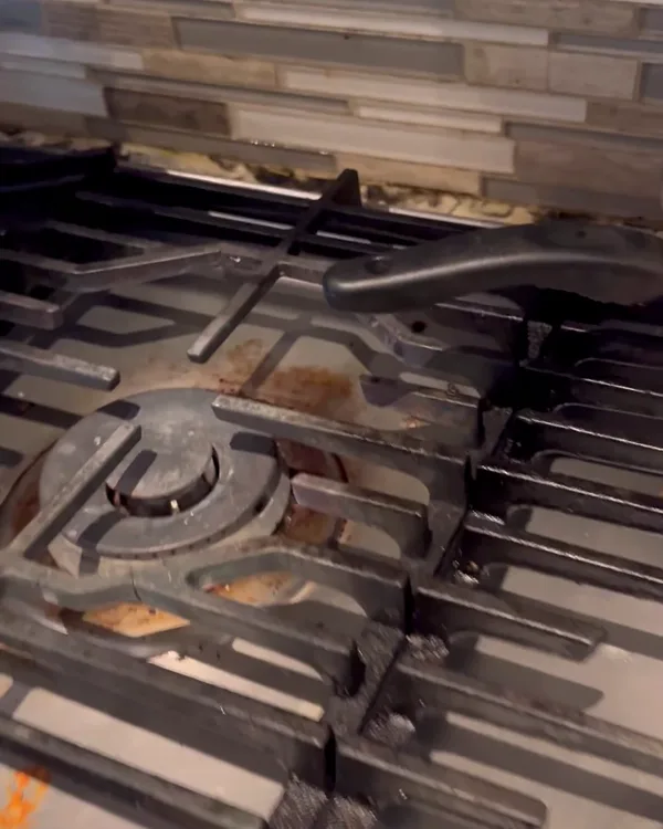 Gas stovetop with grease and burnt food on the grates