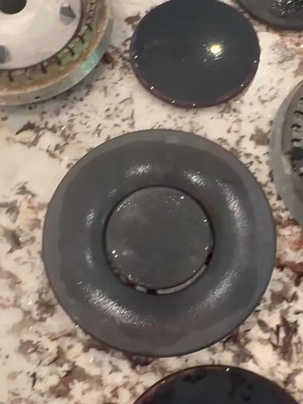 Burner caps laid out on a granite counter