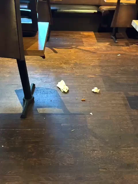Litter on the floor between booth seats and tables