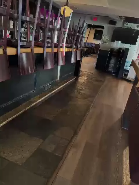 Long view of the clean dining room floor with chairs on the tables