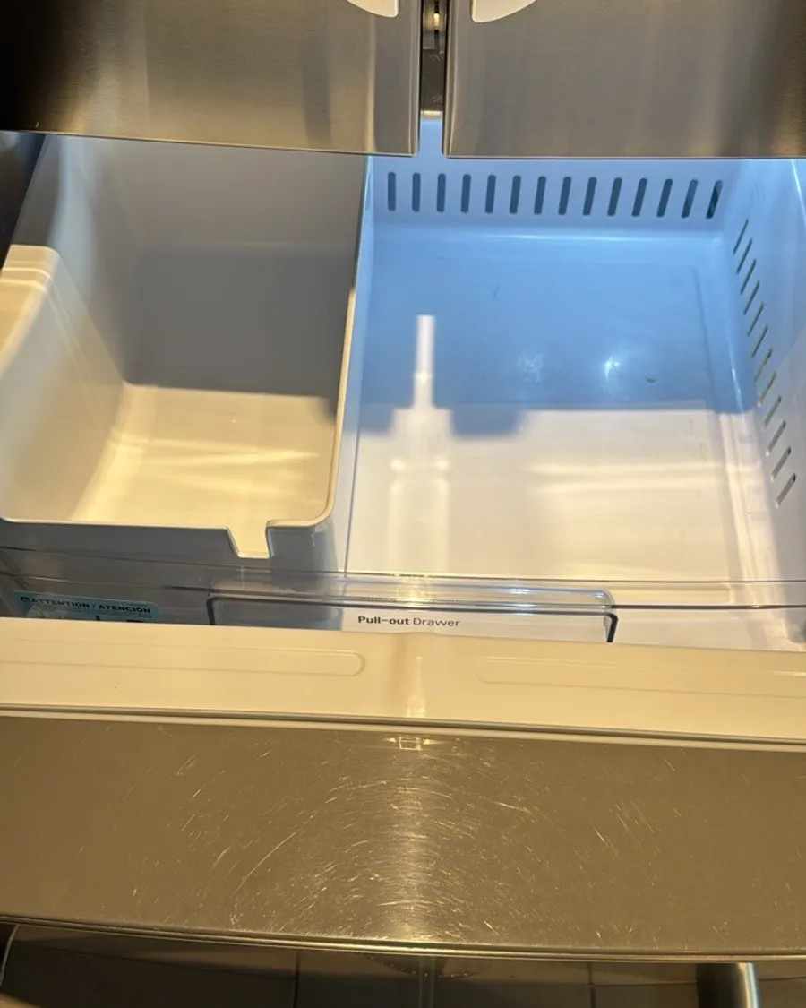 Freezer drawer pulled out with two empty white bins