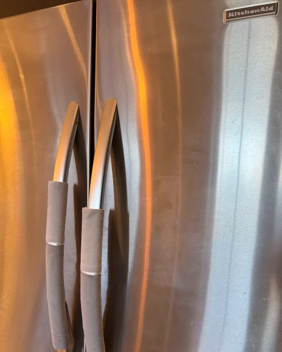 Stainless steel fridge doors with fabric covers on the handles