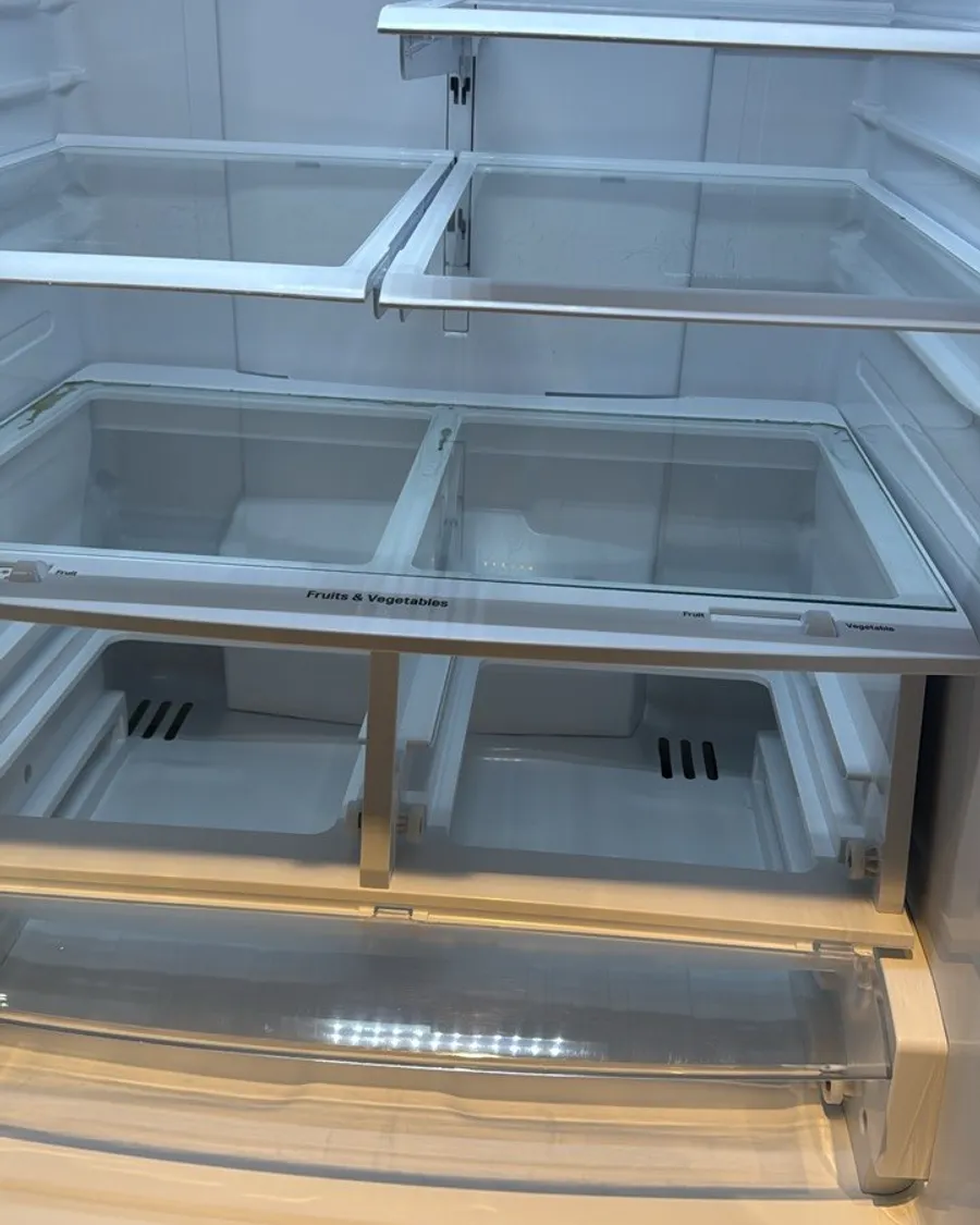 Empty fridge with clean glass shelves and crisper drawers