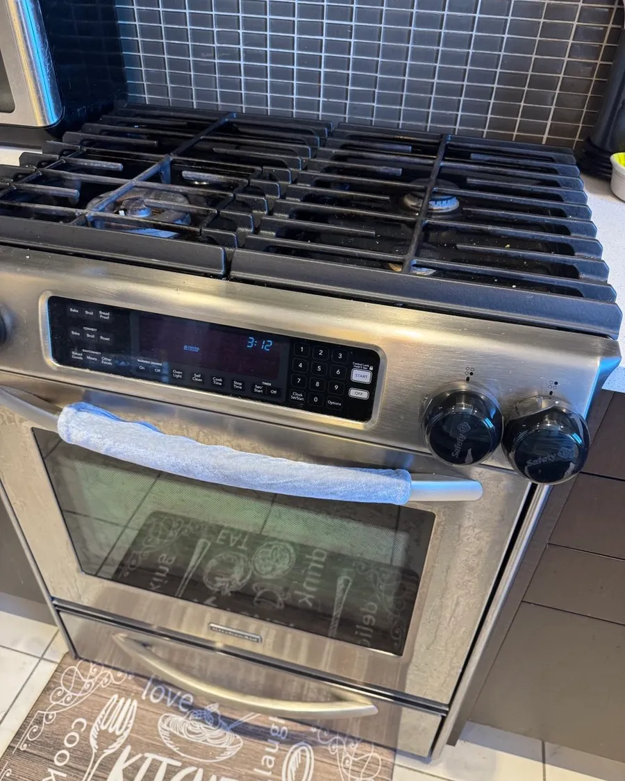 Stainless steel gas range with clean grates, control panel and oven door