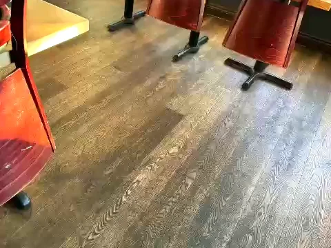 Restaurant dining room floor after cleaning, chairs up on the tables